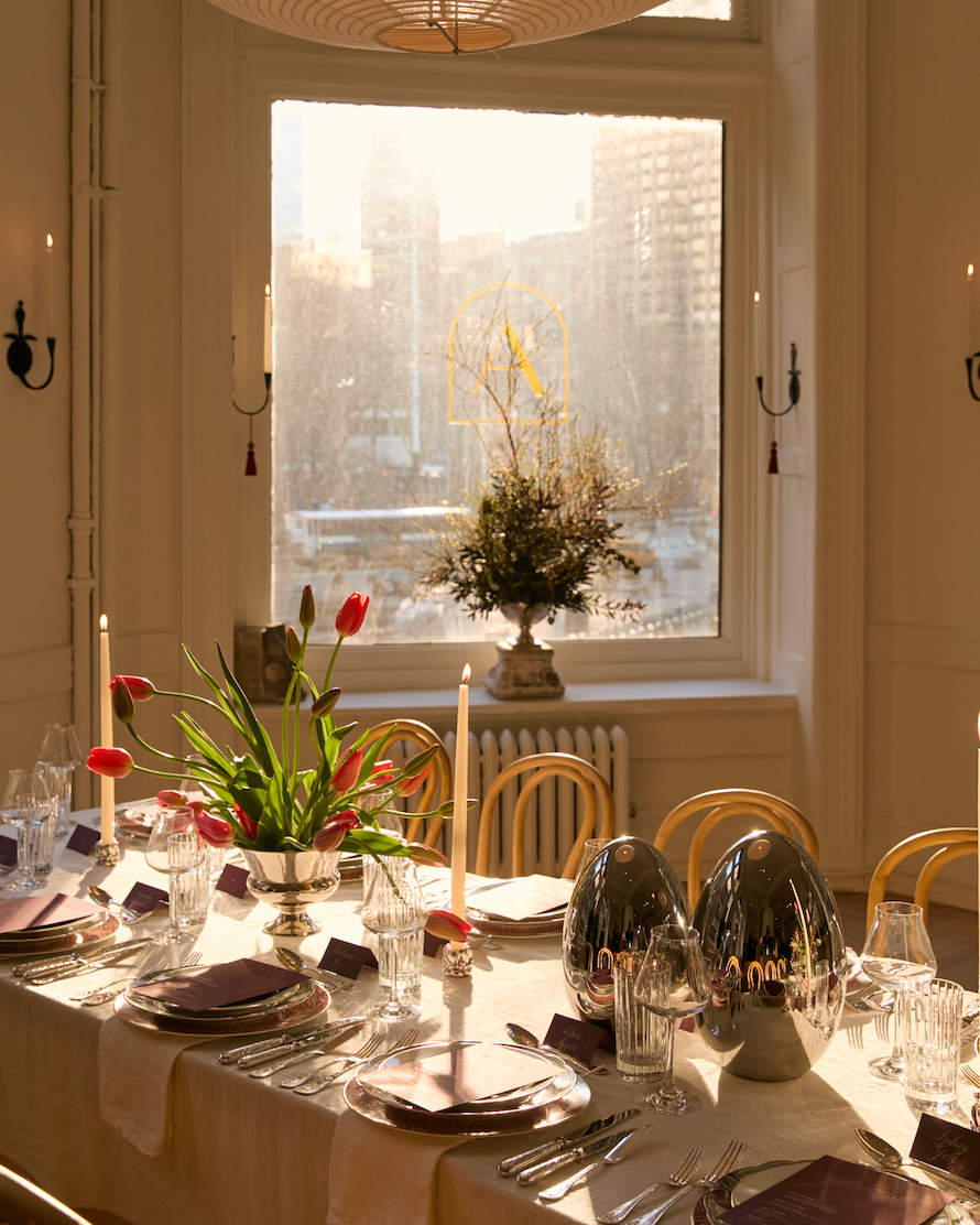 Elegant dining table set up with flowers and decor near a window.
