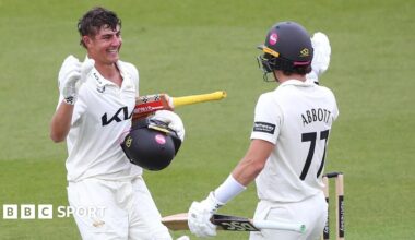 Sean Abbott of Surrey congratulates Adam Thomas after scoring a century against Sussex