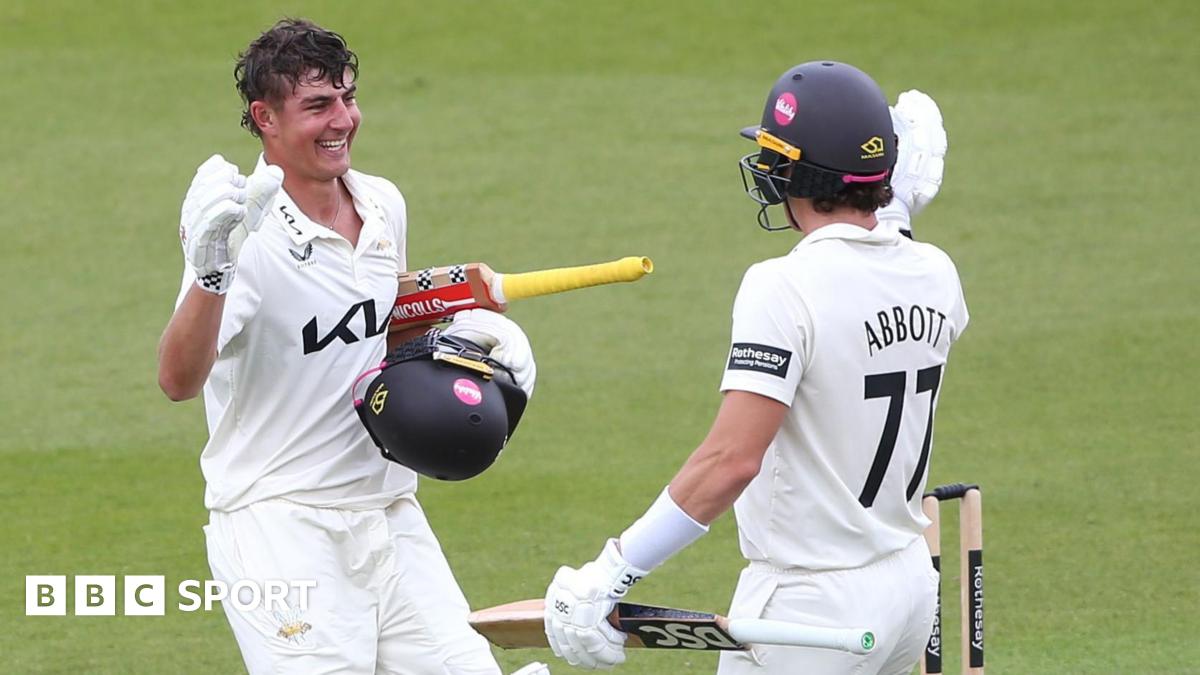 Sean Abbott of Surrey congratulates Adam Thomas after scoring a century against Sussex