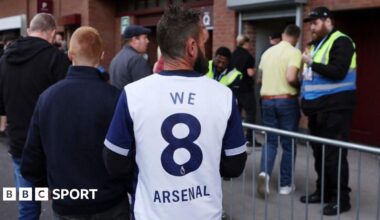A Tottenham fan wearing shirt saying 'We 8 Arsenal'