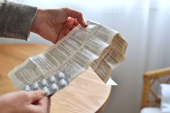 Hands holding blister with pills and patient information leaflet