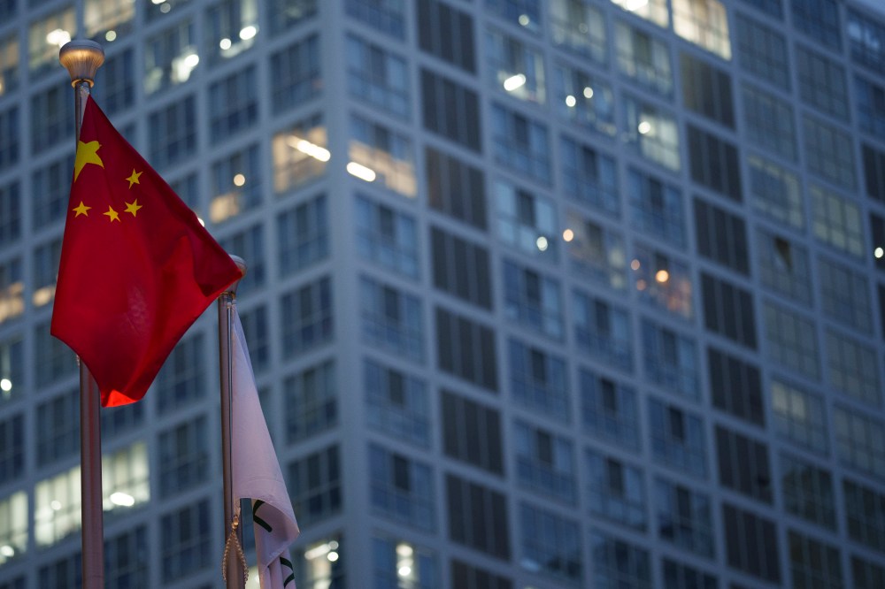 Chinese flag is on display during a ate evening with the background of central business district in Beijing, China, Monday, July 15, 2024. (AP Photo/Vincent Thian)