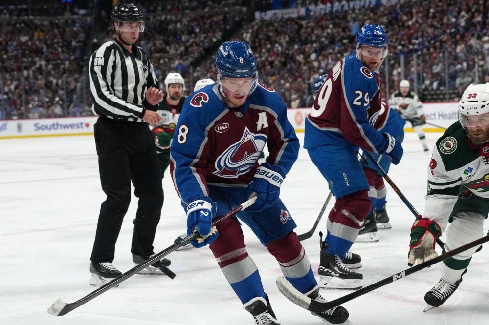 Colorado Avalanche defenseman Cale Makar, left, pursues the puck with Minnesota Wild right wing Ryan Hartman in the second period of Game 2 of an NHL hockey Stanley Cup second-round playoff series Tuesday, May 5, 2026, in Denver. (AP Photo/David Zalubowski)