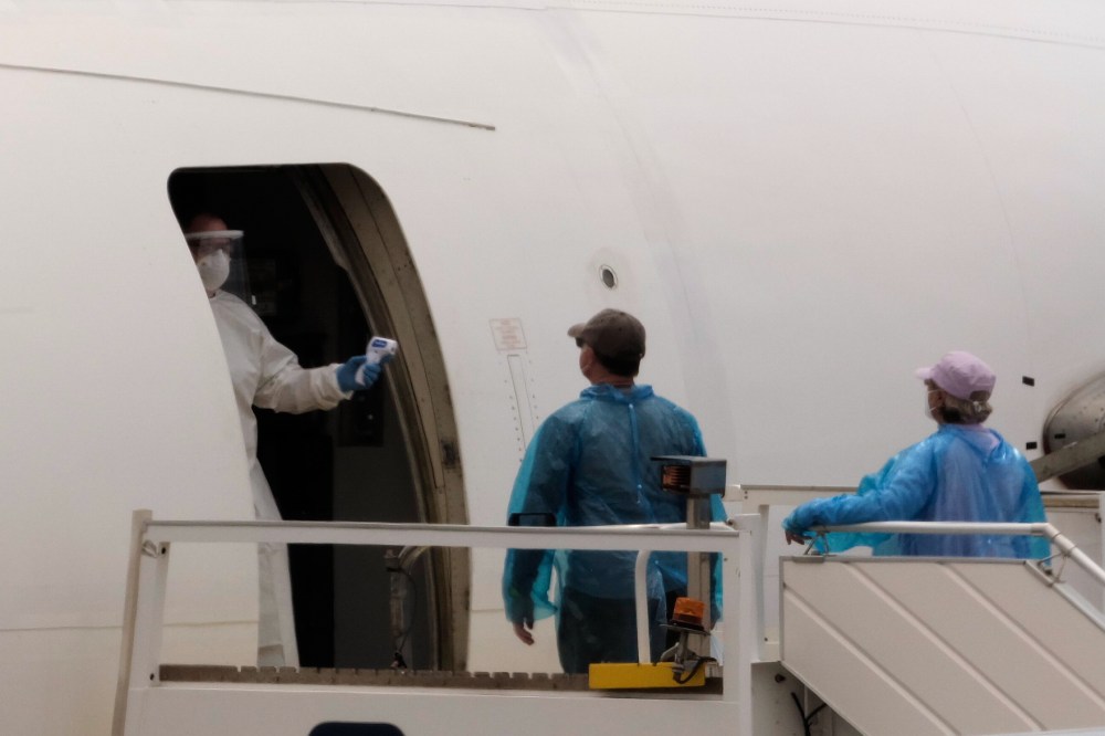 Passengers are screened with a temperature scanner before boarding a plane bound for Canada, after disembarking from the hantavirus-stricken cruise ship MV Hondius at the airport in Tenerife, Canary Islands, Spain, Sunday, May 10, 2026. (AP Photo/Arturo Rodriguez)
