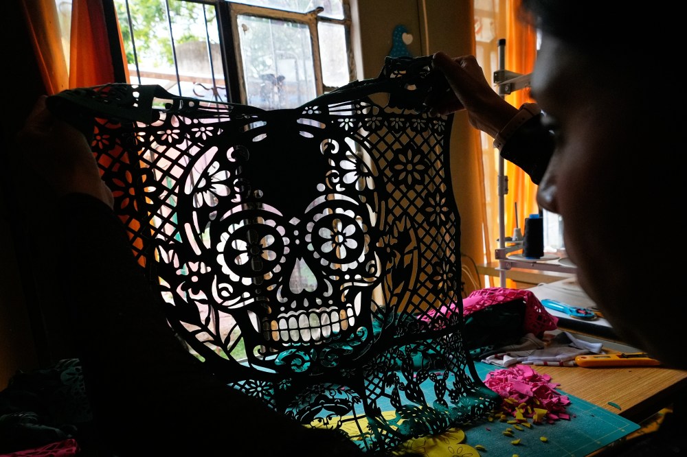 Cande Martinez prepares soccer jerseys, inspired by papel picado and traditional folk art, from the brand Mexclart, in Cuautitlán Izcalli, Mexico, Monday, May 25, 2026. (AP Photo/Marco Ugarte)