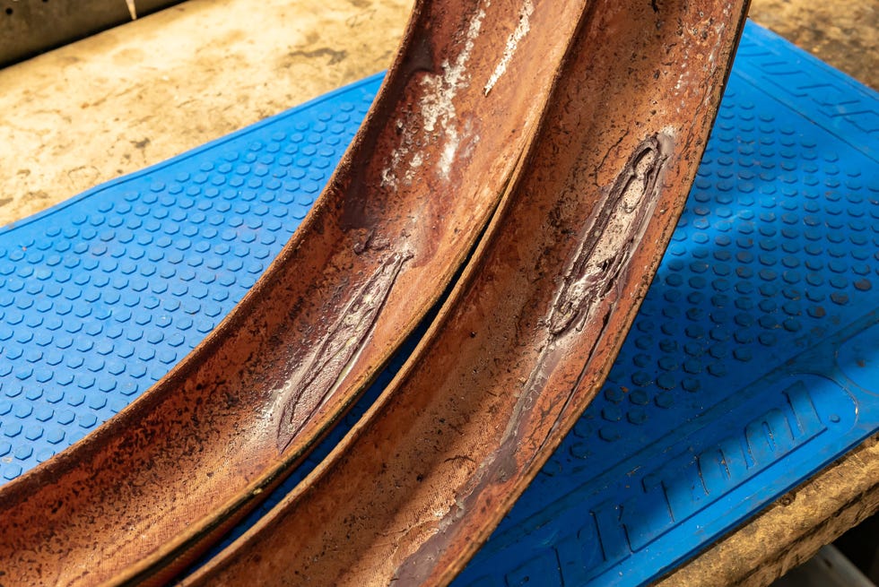 Two curved metal pieces on a blue rubber mat. Two curved metal pieces on a blue rubber mat.