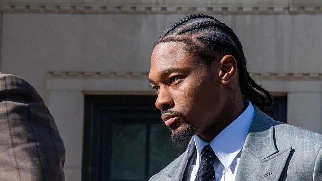 Stefon Diggs, wearing a suit, walks outside a court after the conclusion of a legal case