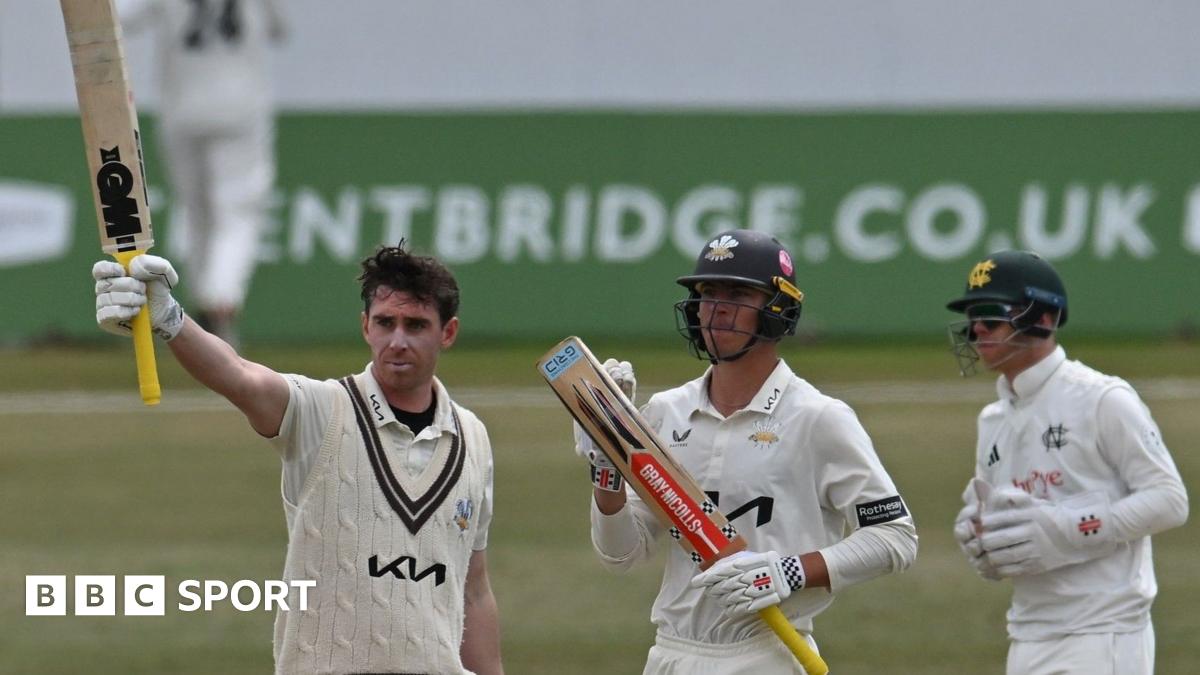 Surrey's Dan Lawrence raises his bat at Trent Bridge after completing a hundred against Nottinghamshire