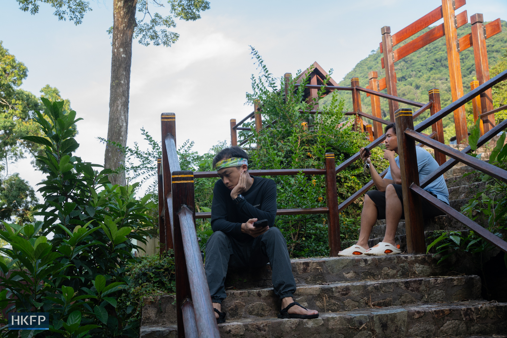 Fung Hon-shing and his colleague James Kwok waiting for the right moment to film a frog species in Tai Po on July 9, 2025.Photo: Kyle Lam/HKFP.