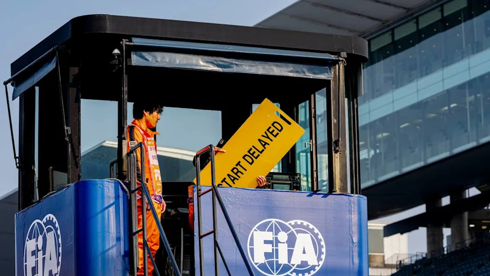 Marshals hold a 'Start Delayed' sign during the 2026 F1 Japanese Grand Prix. Photo by Marcel van Dorst/EYE4IMAGES/NurPhoto via Getty Images