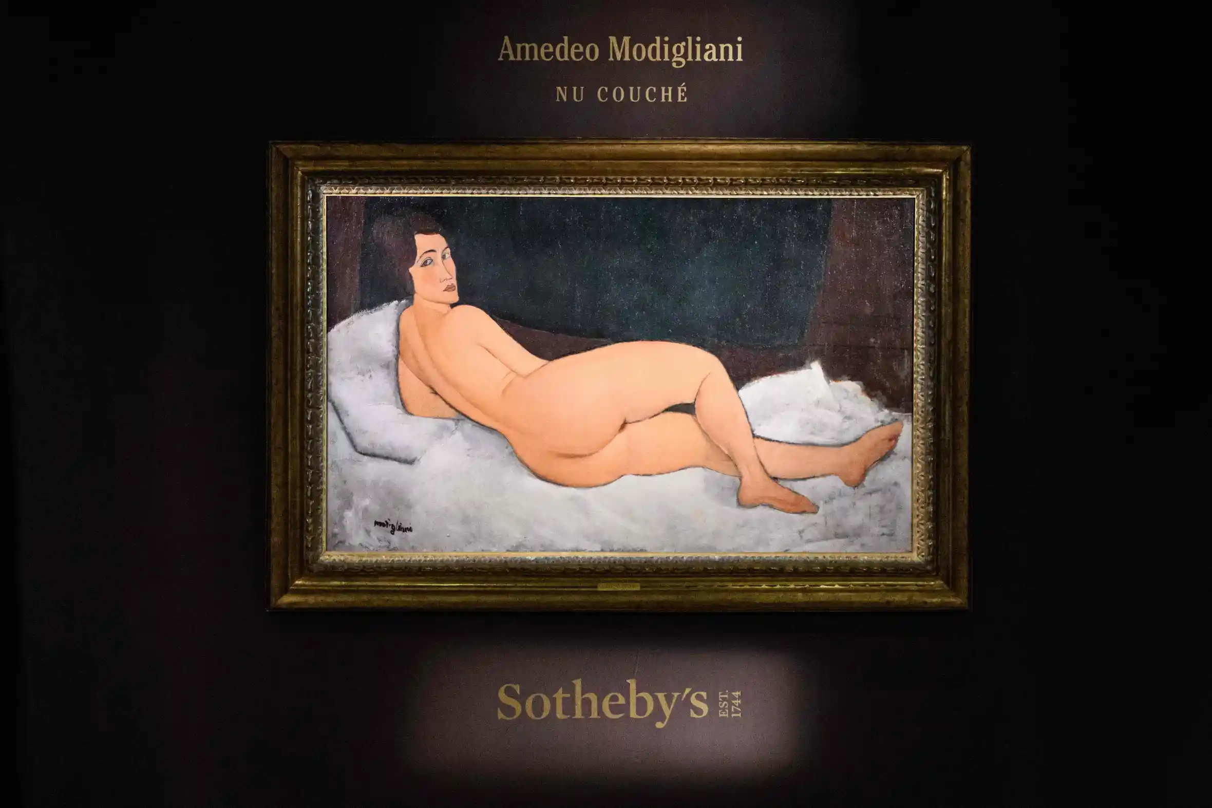 Amedeo Modigliani's "Nu couché (sur le côté gauche)" oil painting, depicting a reclining nude woman, displayed at Sotheby's auction house.