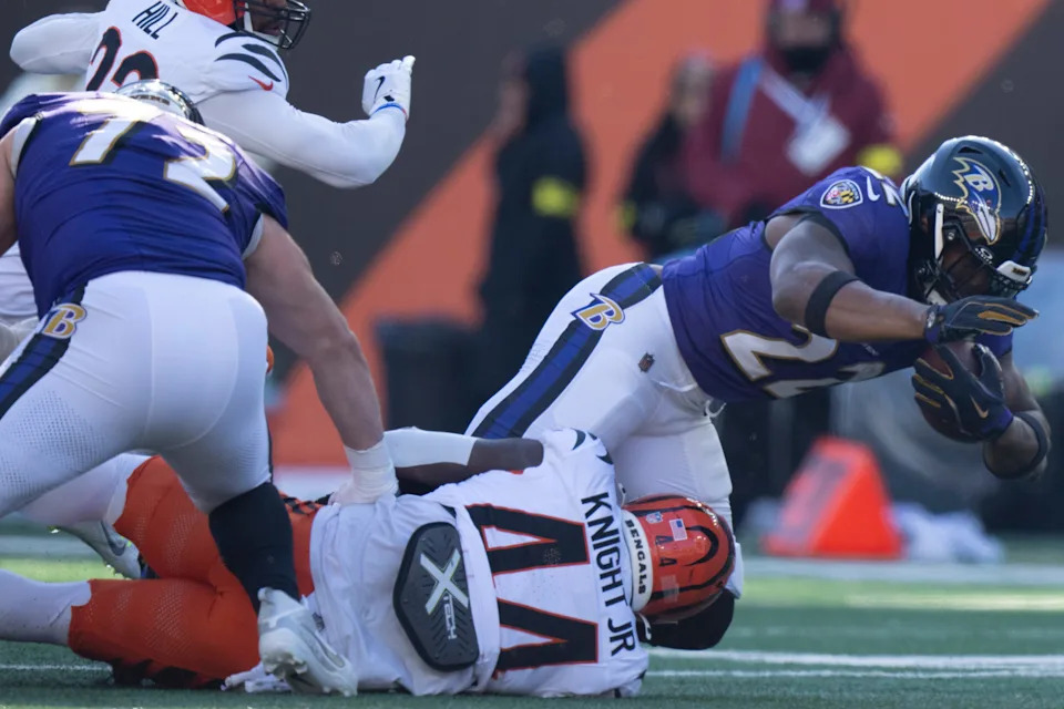 Cincinnati Bengals linebacker Demetrius Knight Jr. tackles Baltimore Ravens running back Derrick Henry.