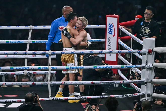 Naoya Inoue (R) embraces Junto Nakatani at the end of round 12 during their super bantamweight championship boxing contest at Tokyo Dome in Tokyo on May 2, 2026. (Photo by Yuichi YAMAZAKI / AFP via Getty Images)