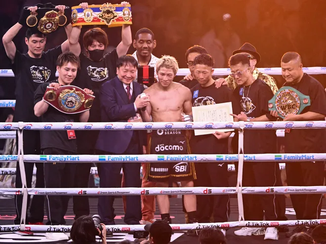 Naoya Inoue (C) poses with members of his team after defeating Junto Nakatani during their Super bantamweight championship contest at Tokyo Dome in Tokyo on May 2, 2026. (Photo by Yuichi YAMAZAKI / AFP via Getty Images)