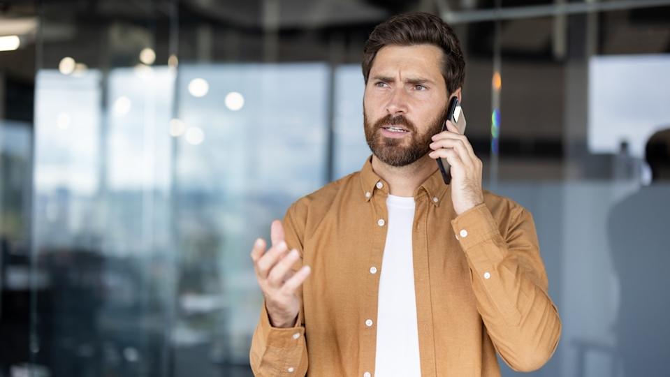 A phone on the phone looking concerned