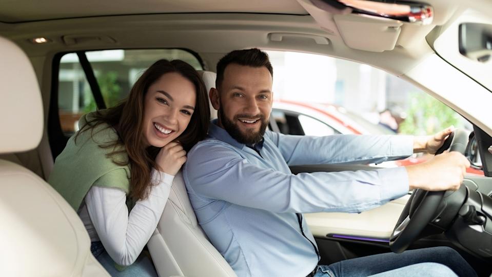 Male and female in car smiling