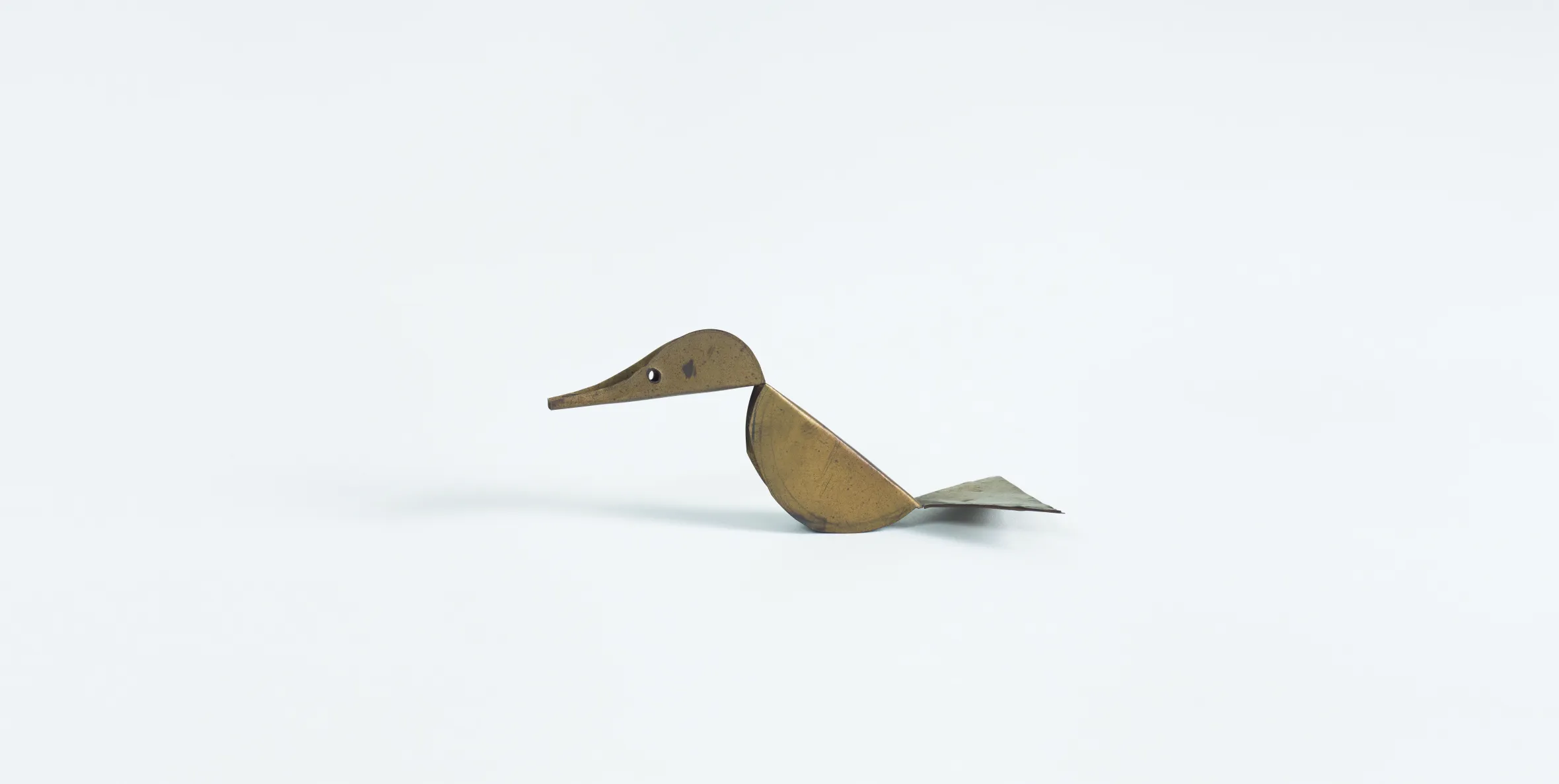 Sculpture of a duck made from brass sheet metal.