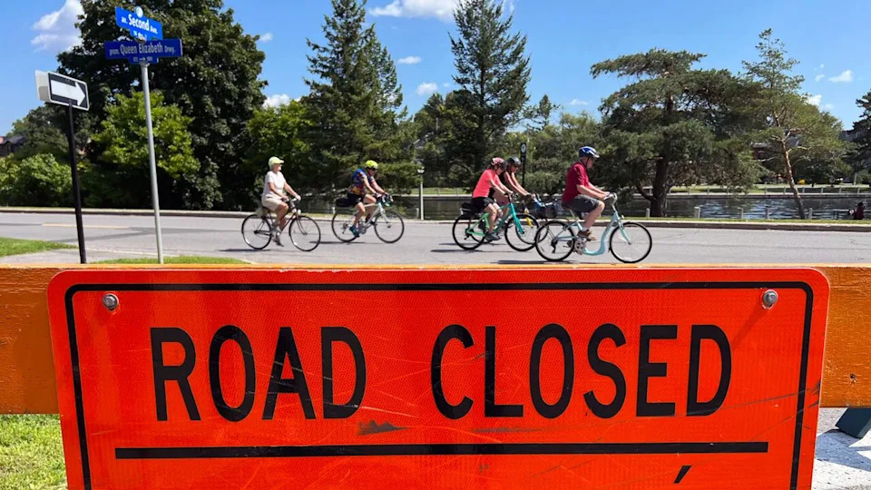 Cyclists ride down a section of the Queen Elizabeth Driveway that's closed to cars on Aug. 23, 2023. Ottawa's mayor has asked the NCC to re-think its program opens the road up to cyclist and pedestrian traffic from May to October.
