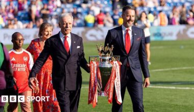 Josh and Stan Kroenke walk trophy out onto pitch