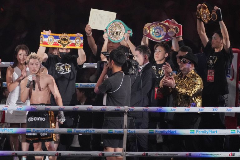 Naoya Inoue of Japan, left, celebrates as he beat Junto Nakatani of Japan in a boxing match for the WBA, WBC, IBF and WBO super bantamweight world title in Tokyo, Saturday, May 2, 2026. (AP Photo/Hiro Komae)
