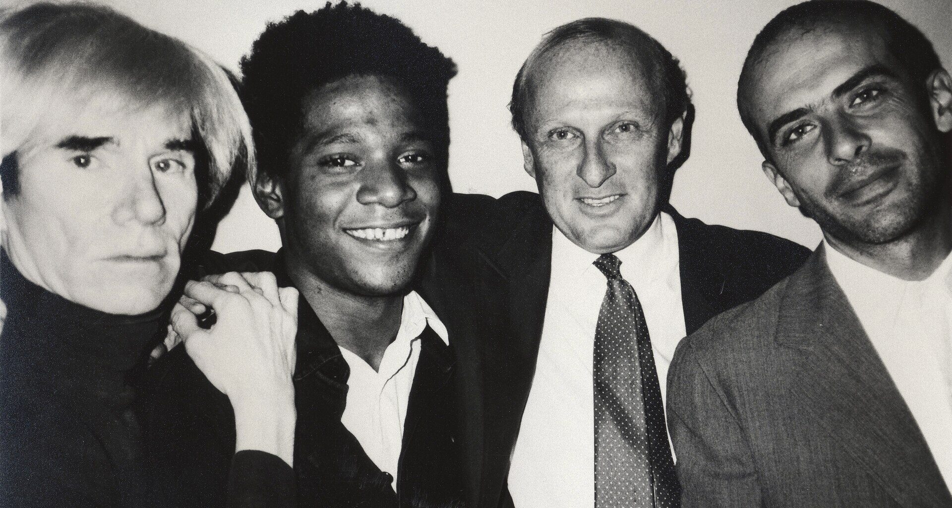 Photo of Andy Warhol, Jean-Michel Basquiat, Bruno Bischofberger and Fransesco Clemente, in New York, 1984.