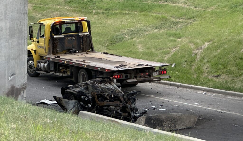 A tow truck retrieves a burnt vehicle on Crowchild Trail NW in Calgary on Tuesday, May 26, 2026