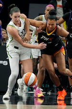 FILE - Former Minnesota Lynx forward Bridget Carleton, left, and Phoenix Mercury forward Satou Sabally battle for a loose ball during the second half of Game 3 of a WNBA basketball playoff semifinals series game, Sept. 26, 2025, in Phoenix. Carleton is now a member of the Portland Fire.