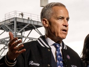 A sniper team from the Prime Minister Protective Detail stand on a tower as PM Mark Carney speaks while touring IUOE Local 793 in Oakville, Ont. on Thursday, April 30, 2026.