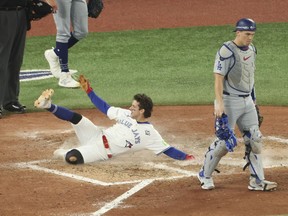Blue Jays baserunner Ernie Clement slides past Dodgers catcher Will Smith after a double by Andres Gimenez in the sixth inning against the Los Angeles Dodgers during Game 7 of the World Series in Toronto, Saturday, Nov. 1, 2025. Jack Boland