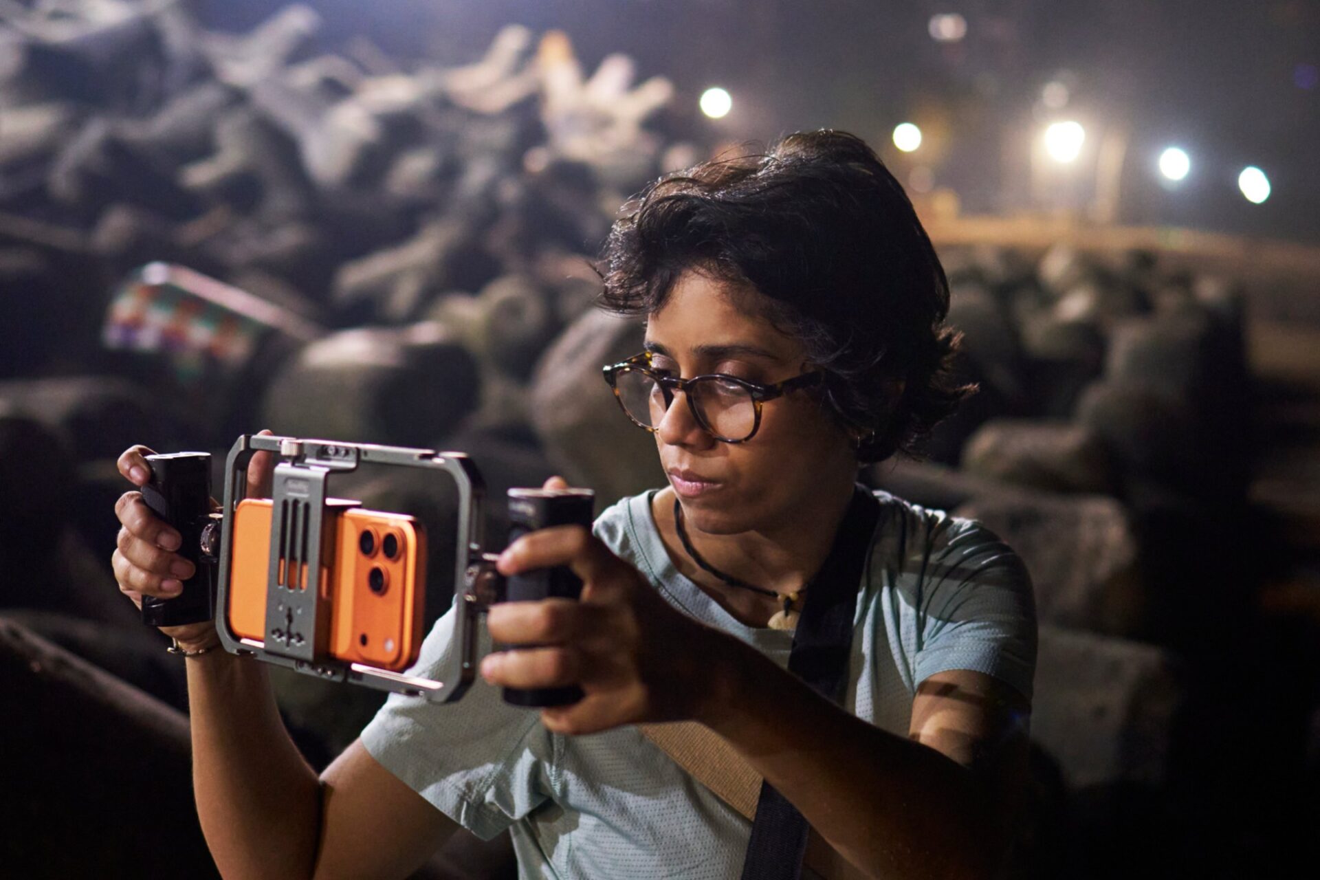 Filmed on iPhone | iPhone in Canada Person wearing glasses uses a handheld camera stabilizer to film outdoors at night.