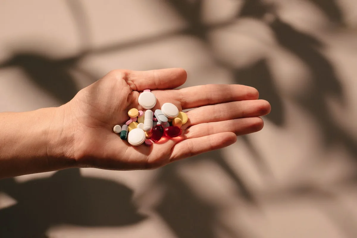 A hand holding out supplements