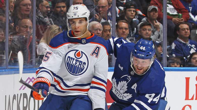 Darnell Nurse #25 of the Edmonton Oilers flips the puck away against Morgan Rielly #44 of the Toronto Maple Leafs during the first period in an NHL game at Scotiabank Arena on March 23, 2024 in Toronto, Ontario, Canada.