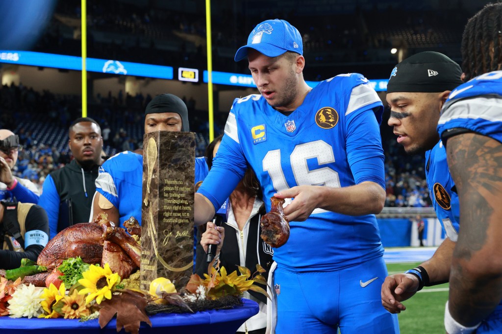 Detroit Lions quarterback Jared Goff #16 takes a turkey leg at the conclusion of an NFL Thanksgiving Day football game between the Chicago Bears and the Detroit Lions at Ford Field in Detroit, Michigan USA, on Thursday, November 28, 2024. 