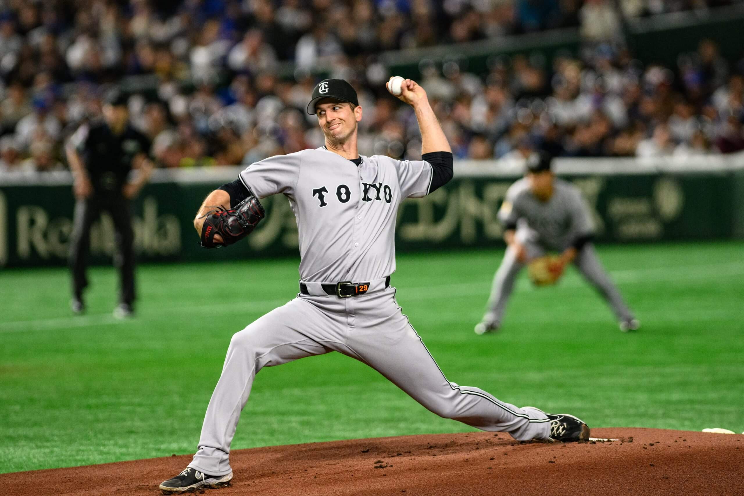 Foster Griffin holds up his left arm to pitch with his right arm out in front of him and his left leg extended behind him on the mound. 