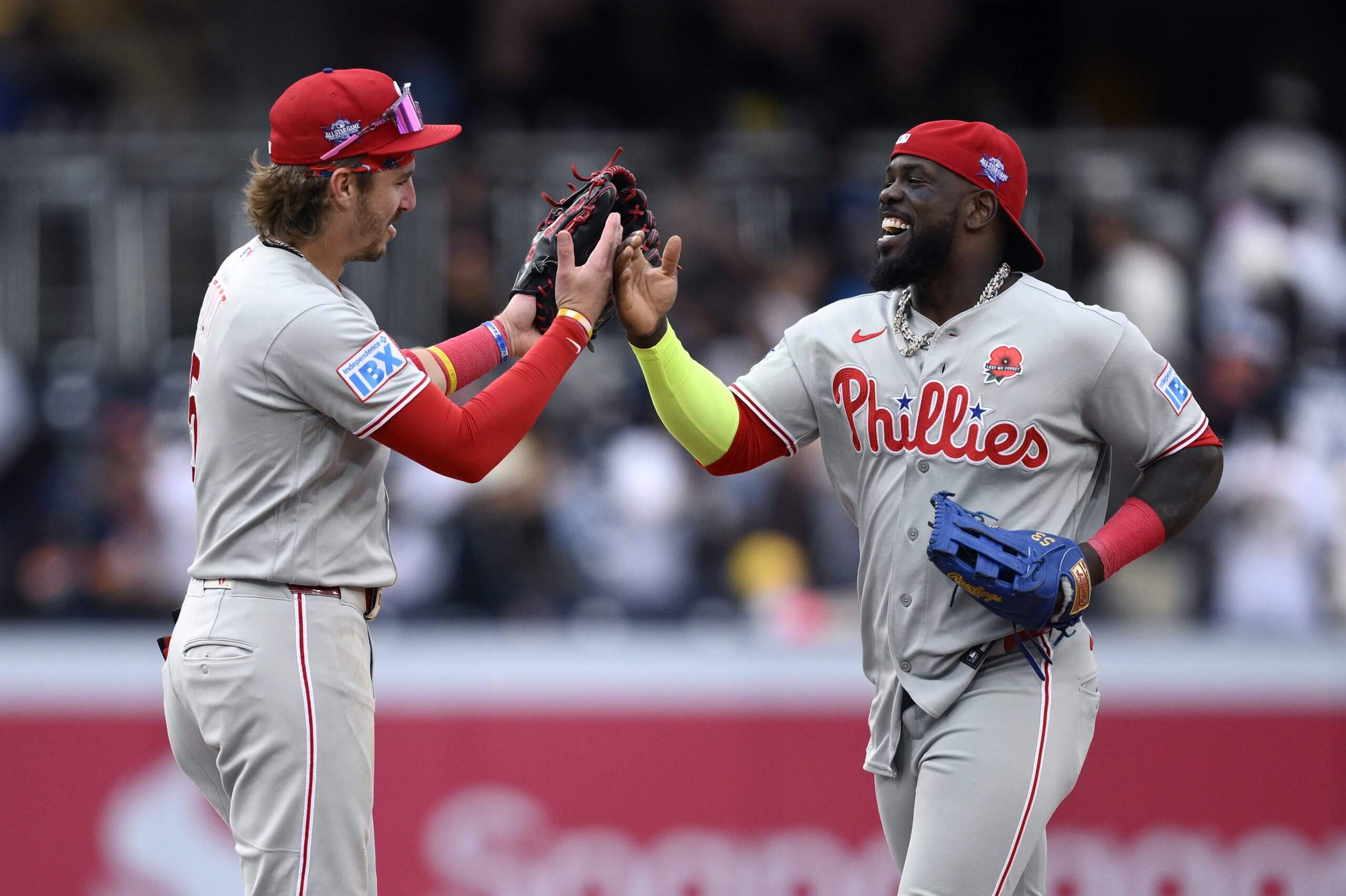 Adolis García and Bryson Stott celebrate after winning the series opener against the Padres.