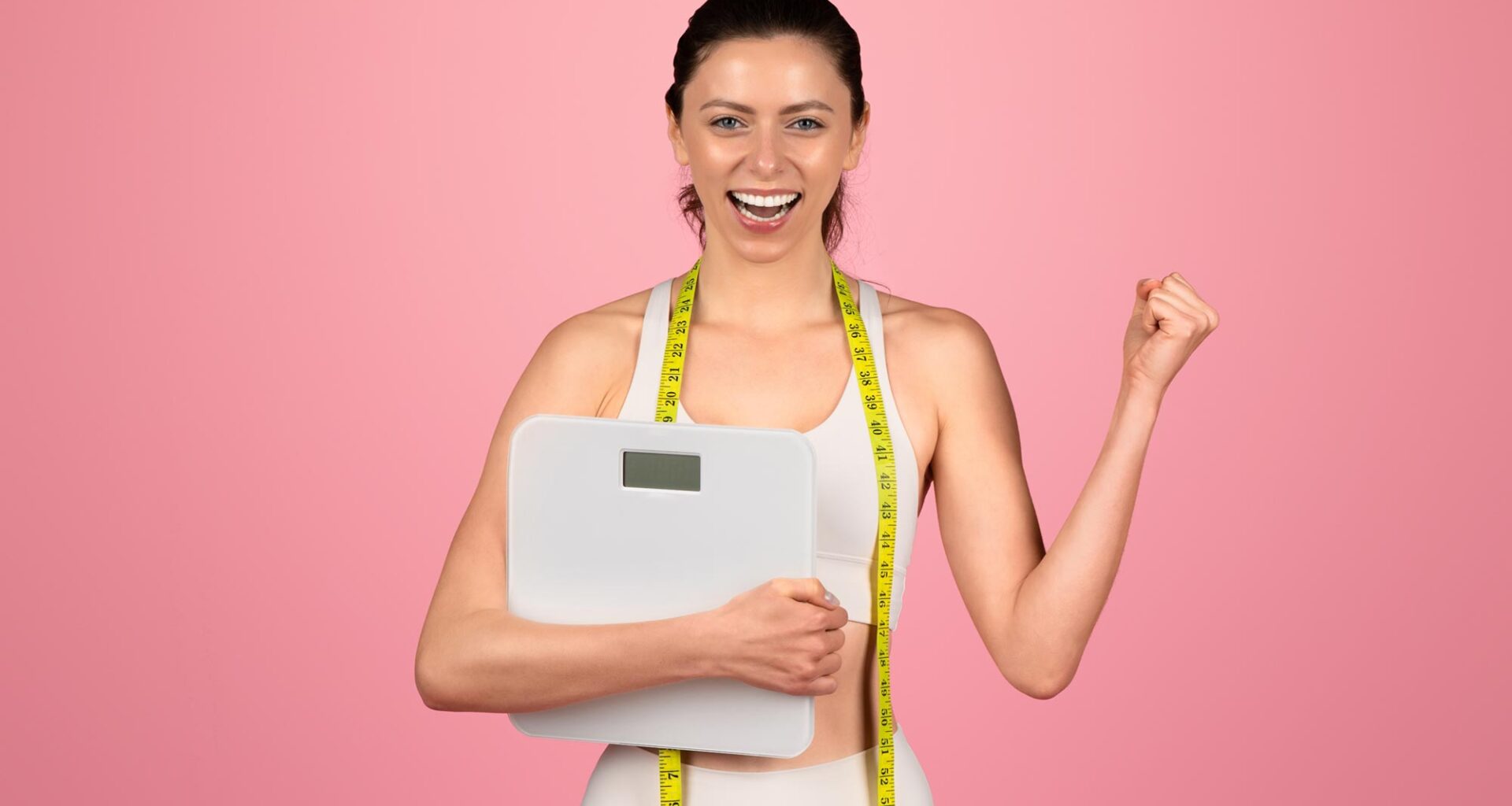 Happy Young Woman Celebrating Weight Loss Success Holding Scale