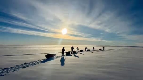 A team of adventurers skiing on the Greenland ice sheet in sunny conditions