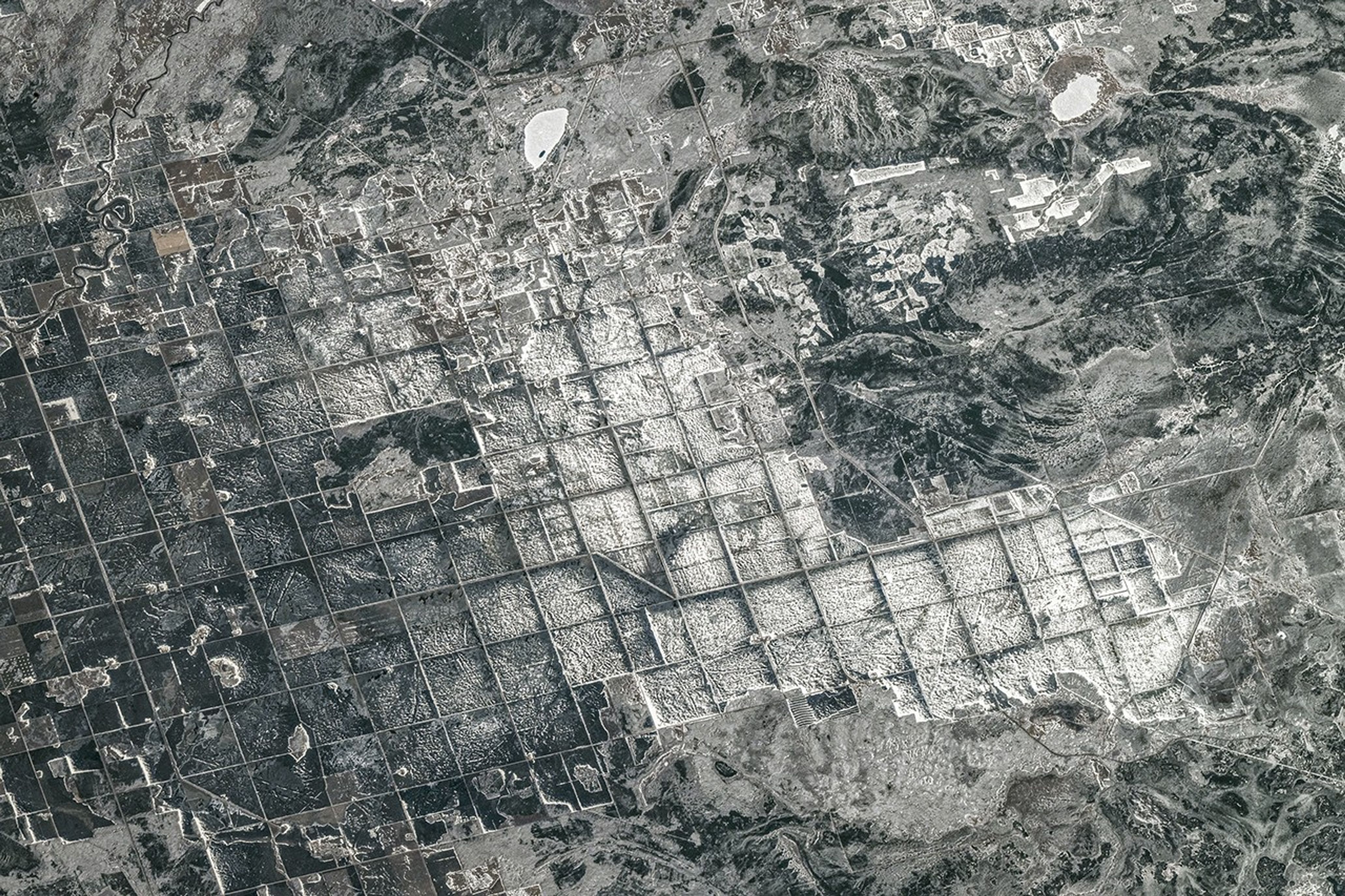 Farm fields and roads are laid out in a repeating rectangular pattern in this snowy image.