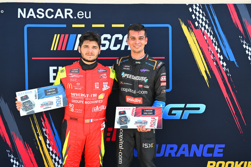 Two race drivers in red and black suits pose with awards on a NASCAR Europe backdrop, each holding a certificate or plaque.