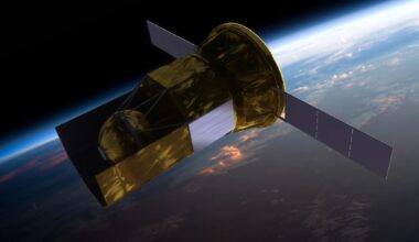 a gold-foiled satellite floats in space above Earth, with two, three-panel solar arrays on either side.