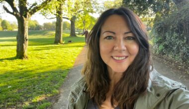 Susan Griffin doing 10-minute walking workout through sunny park, smiling