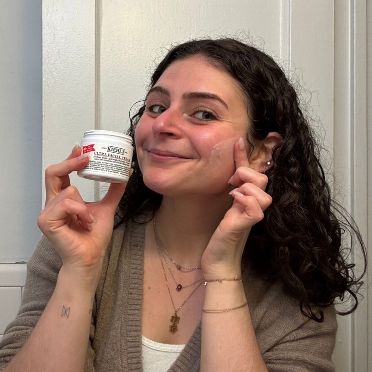 A woman applying Kiehl’s Ultra Facial Cream.