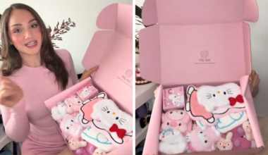 A woman is holding a pink box filled with cute character themed items.