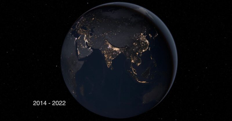 A view of Earth from space at night, showing illuminated city lights across Asia, including India, China, and Southeast Asia. The years "2014 - 2022" are displayed in the bottom left corner.