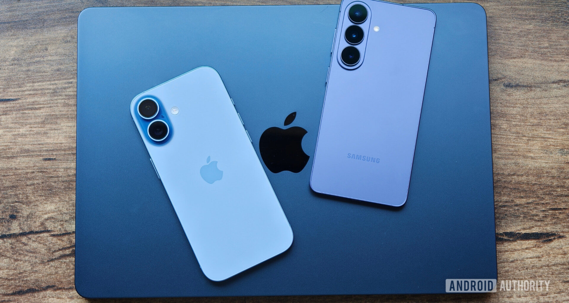MacBook on table with iPhone 17 and Galaxy S26 on top of it