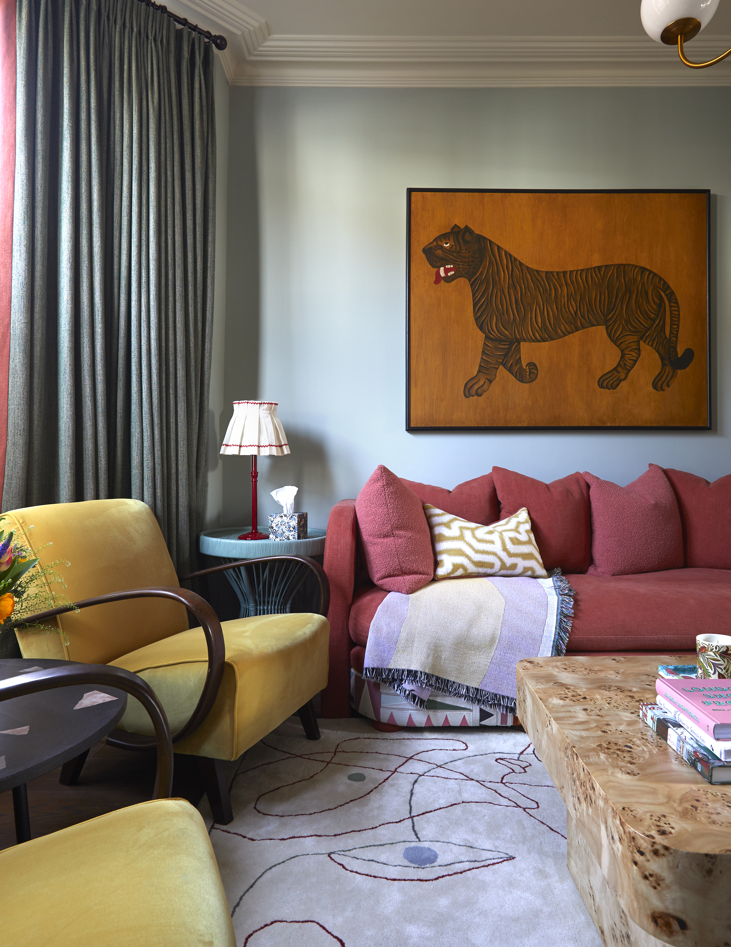 A sitting room painted in mineral blue with colorful upholstery and accessories