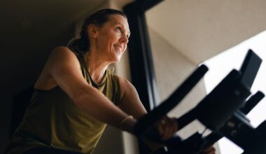 Woman doing 10-minute cycling workout on bike at home, smiling