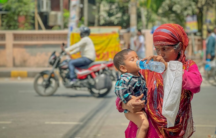 A woman gives water to her son during an ongoing heawave in New Delhi. (Photo: PTI)