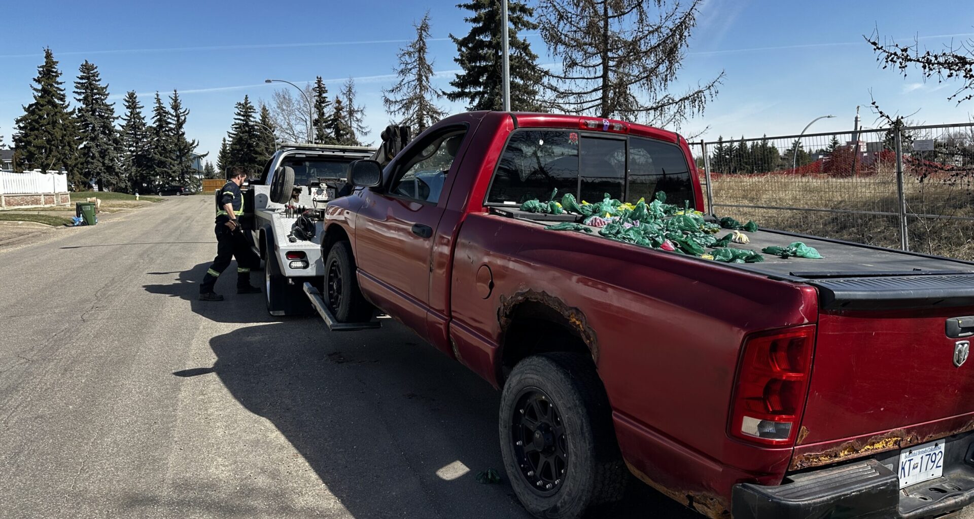 Abandoned red pickup truck with poop bags towed from southwest Edmonton after a year