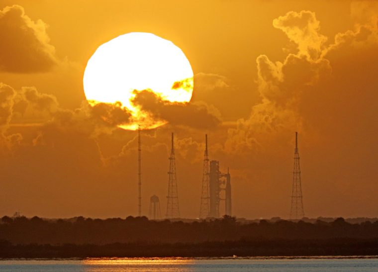 TOPSHOT - NASA's Artemis II Space Launch System (SLS) rocket is seen at sunrise at the Kennedy Space Center in Cape Canaveral, Florida on April 1, 2026. On Wednesday three men and one woman are set to embark on the first crewed journey to the Moon since 1972, a landmark odyssey that aims to launch the US into a new era of space exploration. The NASA mission dubbed Artemis 2 has been years in the making after facing repeated setbacks, but is finally scheduled to take off from Florida as early as April 1 at 6:24 pm (2224 GMT). (Photo by Gregg Newton / AFP via Getty Images)